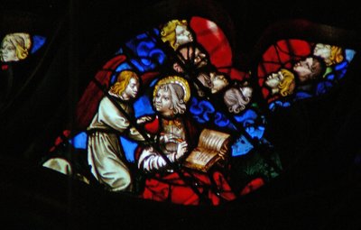Het westelijke roosvenster met een scène uit het Boek Openbaring: hoofden van de zeven donderslagen (in een blauwe wolk) en St. Johannes die verboden wordt te schrijven (10:3-5) door French School