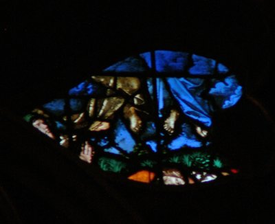 Het westelijke roosvenster met een scène uit het Boek Openbaring: opstanding van de getuigen en hun hemelvaart (in de blauwe wolken) terwijl de toeschouwers verbaasd zijn (11:11-13) door French School