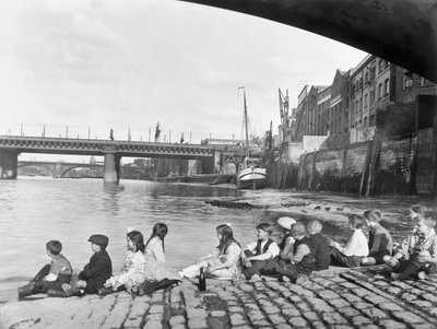 Kinderen op de geplaveide weg onder Southwark Bridge, Londen, ca. 1930 door George Davison Reid