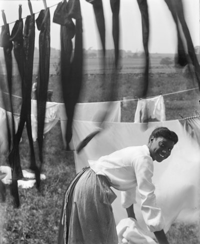 Een jonge Afro-Amerikaanse vrouw hangt wasgoed te drogen in Newport, Rhode Island, ca. 1902 (zw/w foto) door Gertrude Käsebier