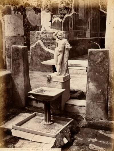 Een fontein bestaande uit een beeld van een naakte jongen. De fontein bevindt zich in het Huis van Balcone pensile, in Pompeii door Giorgio Sommer