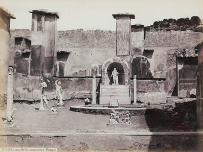 Gedeeltelijk uitzicht op de verhoogde tuin van het Huis van Marcus Lucretius in Pompeii, versierd met marmeren beelden en hermen. In het midden een fontein met een nis. Op de achtergrond fragmenten van muurschilderingen door Giorgio Sommer