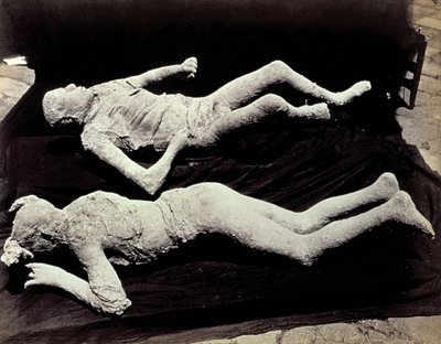 Twee afgietsels van menselijke figuren uit de opgravingen van Pompeii. De tentoonstellingen werden op zwart doek geplaatst om ze te fotograferen door Giorgio Sommer