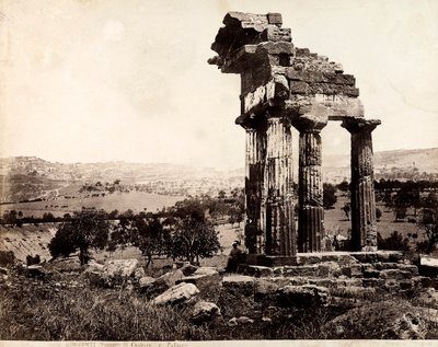 Uitzicht op de resterende vier kolommen die een hoofdgestel ondersteunen van de Tempel van Castor en Pollux in de Valle dei Templi, Agrigento. Een panorama van de stad is zichtbaar op de achtergrond door Giorgio Sommer