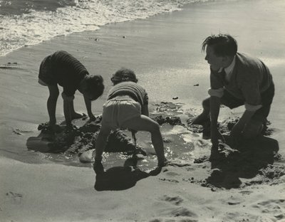 Drie kinderen spelen met zand op het strand door Godfrey Macdominic