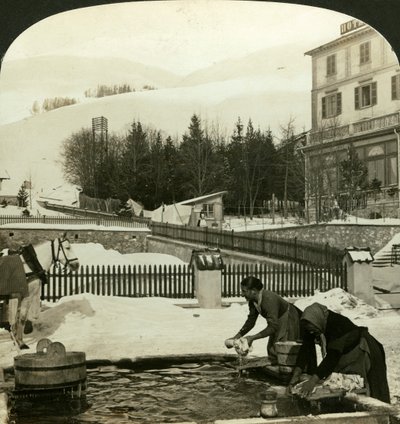 Vrouwen die kleding wassen bij de openbare fontein in hartje winter, Zuoz, Zwitserland door H. C. White
