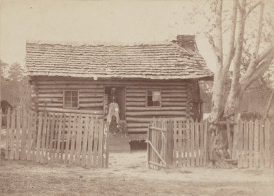 Albuminefoto van een vrouw en twee kinderen voor een blokhut in Georgia door H. S. Clark