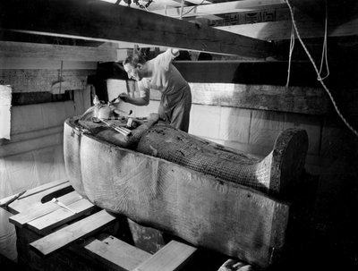 Ontdekking van het graf van farao Toetanchamon in de Vallei der Koningen (Egypte): in de grafkamer, Howard Carter werkt aan het deksel van de tweede kist, oktober 1925, foto door Harry Burton door Harry Burton