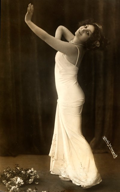 Portret van de Franse actrice Regina Badet in een evocatieve pose, gekleed in een lange witte jurk door Henri Manuel