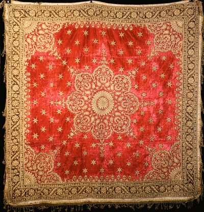 Een scharlaken fluwelen vloerkleed met groene fluwelen rand, dicht geborduurd met vergulde draad door Indian School