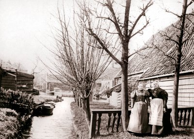 Twee vrouwen aan een kanaaloever, Broek, Nederland, 1898 door James Batkin