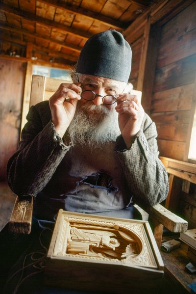 Een meesterbeeldhouwer en orthodoxe priester poseert met zijn werk. Berg Athos, Griekenland. door James L Stanfield