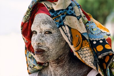 Een vrouw draagt gemalen schorscrème mussiro om haar gezicht te beschermen tegen de zon. Mozambique door James L Stanfield