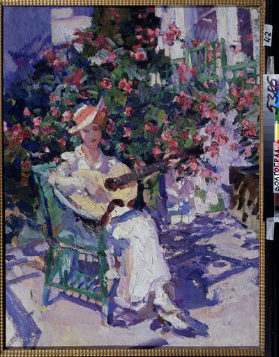 In de Krim. Een jonge vrouw in een lichte zomerjurk zit op een tuinstoel, voor een bloeiende struik, en speelt gitaar. door Konstantin Alekseevich Korovin