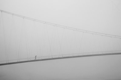 Een eenzame wandeling over een mistige brug door Krunoslav Nevistic