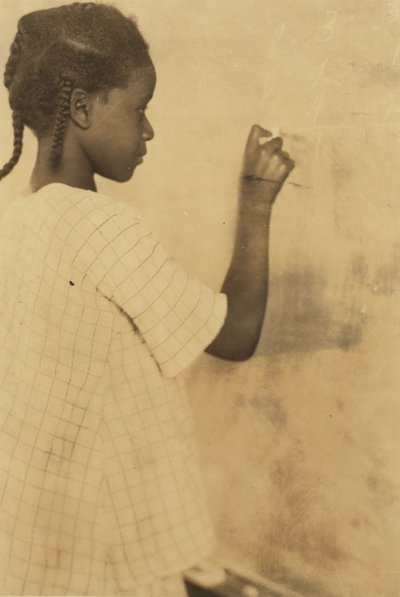Jong meisje schrijft op schoolbord in klaslokaal, Pleasant Green School, Marlinton, Pocahontas County, West Virginia, VS ca. 1921 (sepia foto) door Lewis Wickes Hine