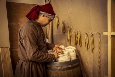 Historische re-enactment: Kaarsen en zakken met tarwe, rogge en gerst in de apotheek van Diotaiuti, Imola, Italië, midden 14e eeuw door Unbekannt Unbekannt