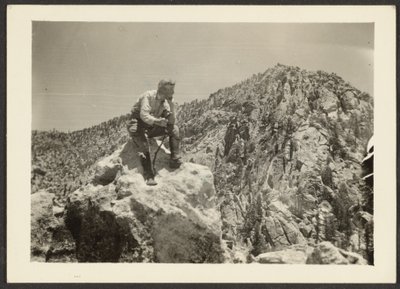 [Man bovenop rotsen]. door Louis Fleckenstein