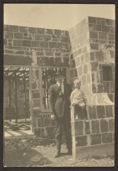 [Staande man met kind in huis in aanbouw]. door Louis Fleckenstein