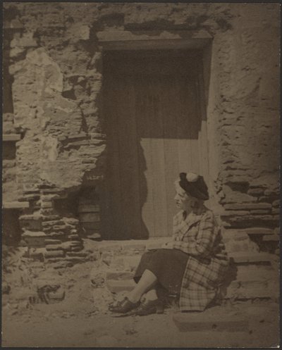 [Vrouw zit voor vervallen gebouw]. door Louis Fleckenstein