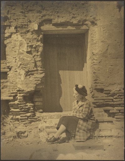 [Vrouw zit voor vervallen gebouw]. door Louis Fleckenstein