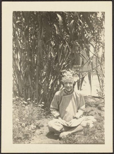 [Vrouw in kostuum zittend in tuin]. door Louis Fleckenstein