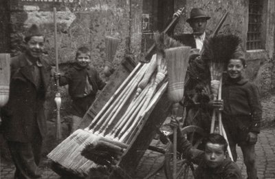 Brooms on street vendors door Luigi Leoni
