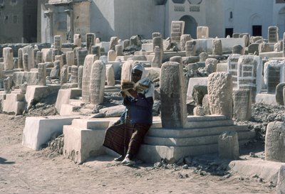 Jemenitische man reciteert de Koran op een begraafplaats met graven in Sayun, Hadramawt, Zuid-Jemen door Lynn Abercrombie
