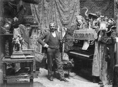 Volledig portret van de schilder Francesco Vinea in de studio van plaats Donatello in Florence. Hij poseert in een kamer versierd met allerlei draperieën, Chinese vazen, kleine sculpturen en snuisterijen. Rechts een piano en een viool door Mario Nunes Vais