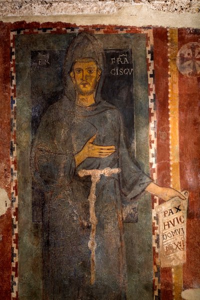 Afbeelding van Sint Franciscus van Assisi (1181-1226) Dit is zeker de eerste afbeelding van de heilige, uitgevoerd terwijl hij nog leefde, zonder stigma en zonder aureool. Hij houdt een papier vast waarop in het Latijn 