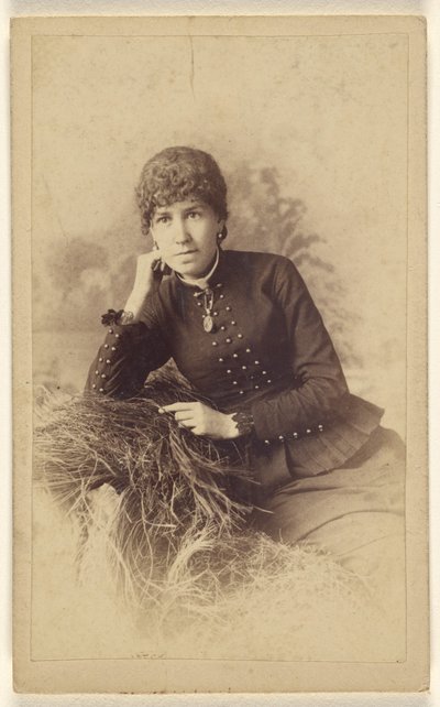 [Ongeïdentificeerde vrouw zittend met hand op wang, poserend op een stapel hooi]. door Miller and Company
