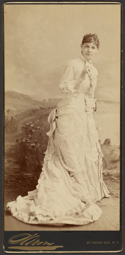 [Ongeïdentificeerde vrouw in een lange, elegante witte jurk, staand]. door Napoleon Sarony