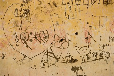 Graffiti gekrast in een oude buitenpleistermuur door Nathan Benn