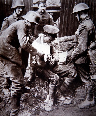 Duitse medische ordonnans verzorgt een gewonde Britse soldaat aan het Westfront tijdens WOI door Photographer German
