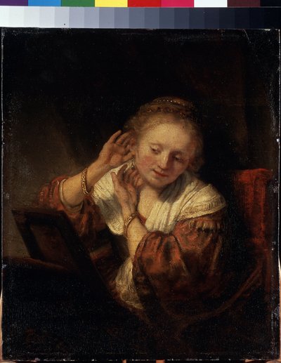 Jonge vrouw die oorbellen probeert door Rembrandt Harmensz. van Rijn