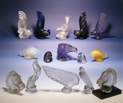 Verschillende glazen automascottes (van vogels, vissen, paarden en een mensenhoofd) door Rene Jules Lalique