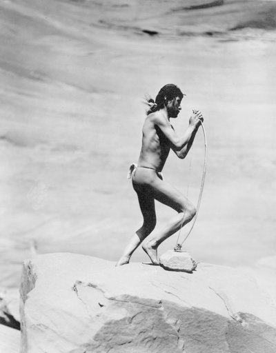 Navajo Indiaan die de boog spant, ca. 1913 door Roland W. Reed