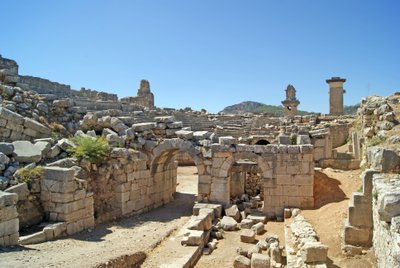 Uitzicht door de gewelfde ingang van het Xanthos-theater naar de orkestbak, met zuil en Harpy-tombe, Xanthos, Turkije door Roman