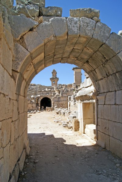 Uitzicht door de gewelfde ingang van het Xanthos-theater naar de orkestbak, met zuil en Harpy-tombe, Xanthos, Turkije door Roman