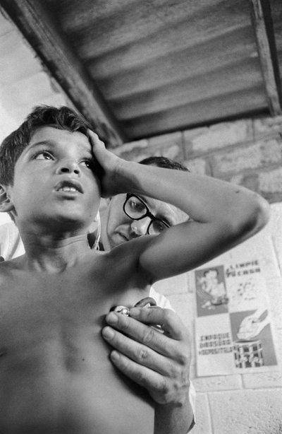 Amerikaanse arts gebruikt stethoscoop om een ziek Ecuadoraans kind te diagnosticeren op ziekenhuisschip SS Hope door Ted Spiegel