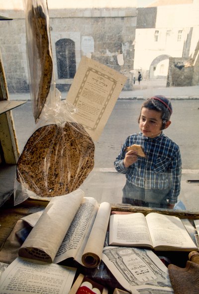Conservatieve Joodse jongen eet cake en kijkt in een religieuze boekwinkel door Ted Spiegel