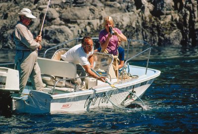 Een visser filmt zijn vangst terwijl hij een zalm binnenhaalt in Bute Inlet door Ted Spiegel