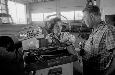 Vrachtwagenchauffeur Mildred Cooper praat met monteur in een garage door Ted Spiegel