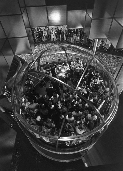 Bezoekers van de Wereldtentoonstelling van Seattle in een koepellift in een tentoonstelling door Ted Spiegel