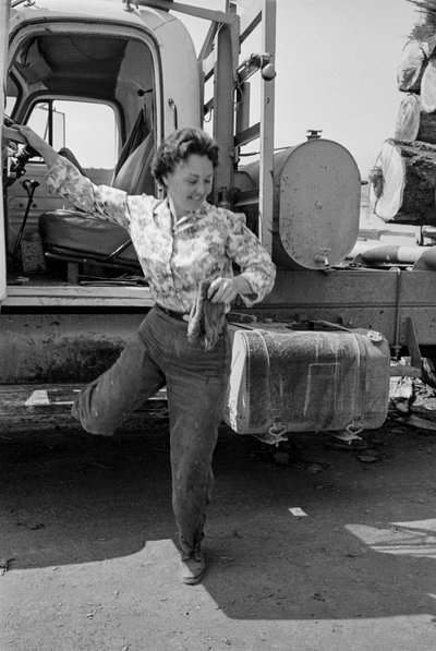 Vrouwelijke vrachtwagenchauffeur Mildred Cooper stapt uit de cabine van haar vrachtwagen door Ted Spiegel