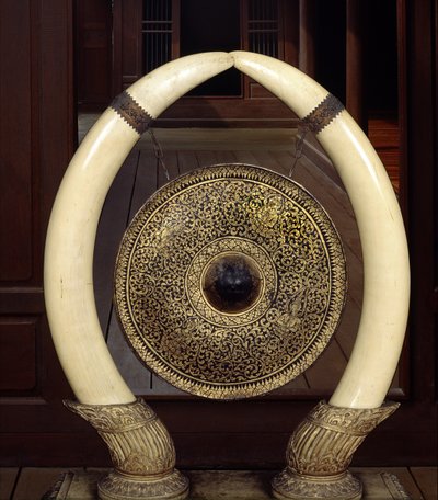 Een gong hangend aan olifantenslagtanden (metaal en ivoor) door Thai School
