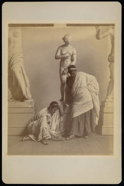 [Twee mannelijke studenten in Griekse kleding voor een gipsafgietsel van Aphrodite in de afgietselkamer van de Pennsylvania Academy]. door Thomas Eakins