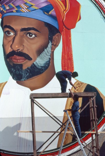 Arbeiders onderhouden een gigantische muurschildering van Qaboos bin Said Al Said, Sultan van Oman door Thomas J. Abercrombie