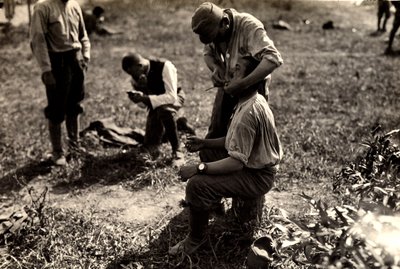 Oostenrijkse gevangenen tijdens de Eerste Wereldoorlog in Bagnaria Arsa, Udine, Italië; op de voorgrond scheert een soldaat een mede-soldaat, 02/04/1916 door Ugo Ojetti
