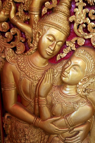20151028, Vientiane, Laos: Wat Ong Teu boeddhistische tempel. Deurpost gravure die een scène uit de Ramayana uitbeeldt door Unbekannt